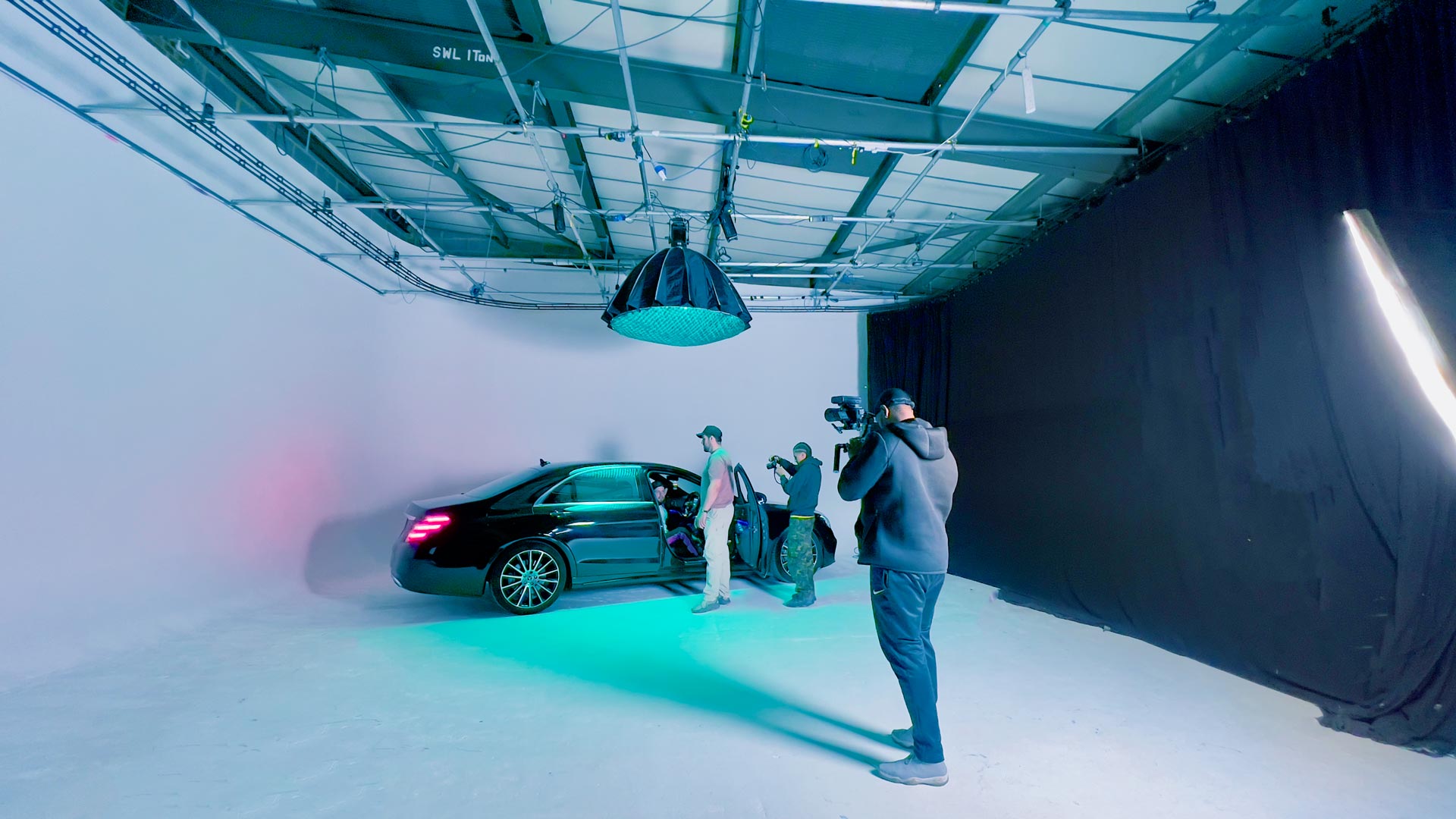 Car and film crew working under coloured lighting inside Cineview Studios